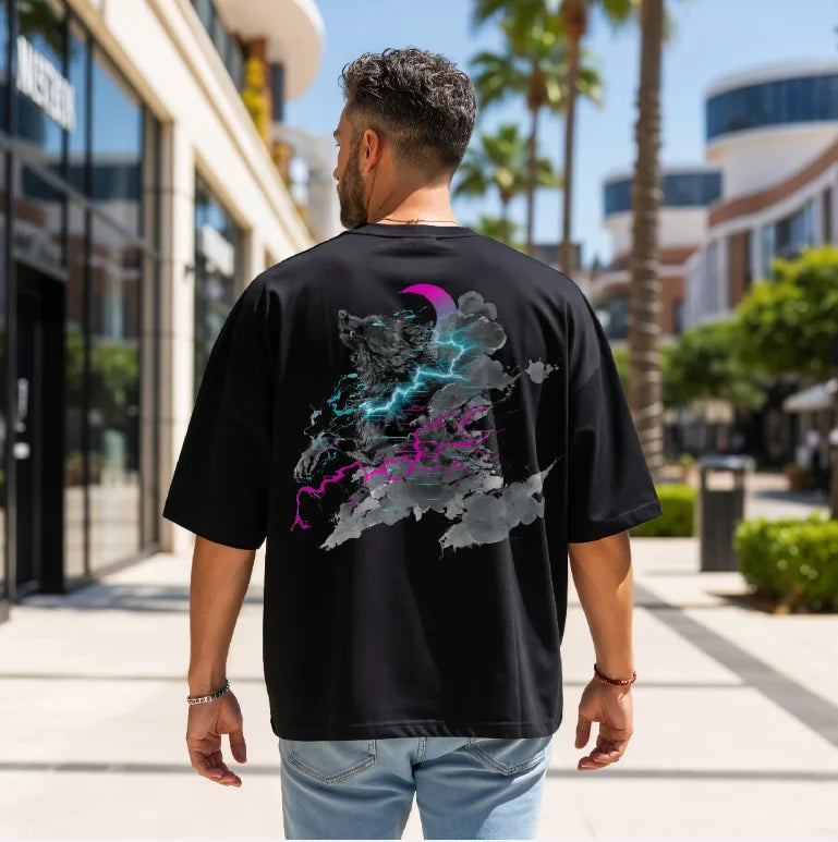 Digital sumi-e ink artwork of a wolf breaking through storm clouds with neon lightning under a crescent moon, printed on the back of a black unisex Comfort Colors oversized t-shirt.